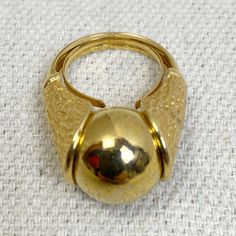 Amazing gold tone ring with Textured sides holding a gold tone orb Originally would have been in a set with different colored marbles (this one has only the single gold marble) Signed Pat Pend  I believe this to be an unsigned Trifari ring In great vintage condition with light color fade There is a built in wire to adjust size from approx size 5 up to 6 Antique Gold Domed Ring, Antique Domed Gold Ring, Gold Domed Collectible Ring, Gold Metal Dome Ring For Anniversary, Vintage Yellow Gold Dome Ring With Polished Finish, Gold Dome Ring With Cabochon For Formal Events, Vintage Gold Metal Rings, Antique Gold Dome Ring With Polished Finish, Gold Cabochon Domed Rings