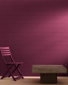 a wooden bench sitting in front of a purple wall with a chair next to it