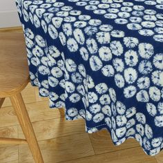 a blue and white tablecloth with flowers on it sitting on top of a wooden floor