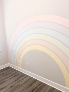 an empty room with a painted rainbow wall