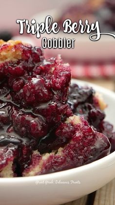 a white bowl filled with blueberry cobbler on top of a wooden table