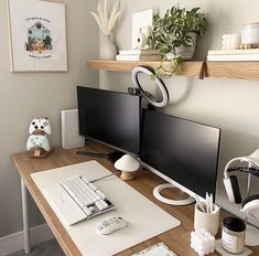 a desk with two computer monitors and a keyboard on it, along with other office supplies