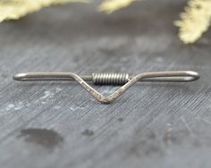 a pair of nails sitting on top of a piece of wood next to yellow flowers