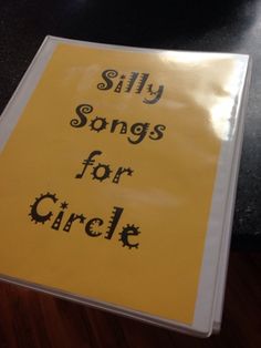 a yellow sign that says silly songs for circle on the side of a black table