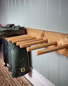 a coat rack made out of wood with clothes hanging from it's hooks on the wall