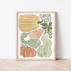 an art print with vegetables on it in a wooden frame next to a white wall