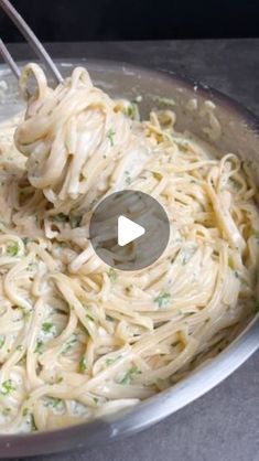 a pan filled with pasta and broccoli being stirred by a ladle in it