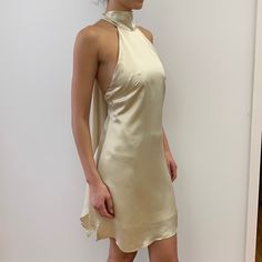 Backless, Tie Back Halter Dress. Fabric Is 100% Satin Cupro. Color Is An Off White, “Champagne” Color. Model Is 5’ 91/2” Tall. Dress Length Is 33 1/2” From Halter Neck Seam To Hem At Center Front. Side Zipper. Brand New Without Tags. Halter Tie Neck Dress, Cream Satin Mini Dress For Night Out, Cream Sleeveless Party Slip Dress, Cream Sleeveless Slip Dress For Party, Chic Gold Slip Dress For Evening, Elegant Cream Slip Dress For Party, Cream Satin Sleeveless Mini Dress, Cream Sleeveless Satin Mini Dress, Chic Gold Sleeveless Slip Dress