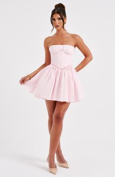 This mini is having a moment! Made in a premium cotton blend fabric, this strapless design features a boned corset to snatch the waist and a super full skirt. The look is complete with delicate lace trims and shirring to the back. 



Colour: Blush.

Premium non-stretch cotton blend fabric.

Fully lined.

Strapless with lace trim.

Gathered, underwired cups.

Boning in corset.

Lace trim detail.

Super full skirt.

Shirred back detail.

Mini length.

Model is an XS and is wearing an XS.

 Size: