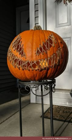 a large pumpkin sitting on top of a metal stand