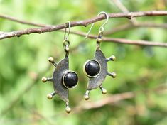 "Unique unusual earrings with gemstone. Made from bronze and decorated with black onyx. Handmade and designed by a jeweler with more than 30 years of experience in jewelry making and designing. Bronze earrings have sterling silver 925 hooks. Please note, that each gemstone is unique, therefore the color of the stone can slightly differ from the ones you see in the pictures. If you would like to order the same design earrings in sterling silver 925 or with another gemstone, please, contact us! PR Black Gemstone Earrings For Anniversary, Round Metal Jewelry With Black Enamel, Black Enamel Round Metal Jewelry, Modern Brass Earrings With Gemstones, Modern Bronze Earrings As Gift, Black Bohemian Sterling Silver Earrings, Antique Black Pierced Earrings, Antique Black Earrings For Gift, Modern Black Jewelry With Oxidized Finish