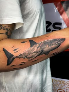 a man with a shark tattoo on his arm