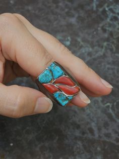 This fantastic ring displays deep red Mediterranean coral inlays flanked by natural, handshaped turquoise inlays. The components are inlayed, yet rise above the surface. The shank of the ring is heavily cast silver. c. 1950s Size: 13 Height: 1" Weight: 22g Artisan Red Jewelry With Inlay, Artisan Red Inlay Jewelry, Artisan Turquoise Ring With Polished Finish, Red Inlay Ring, Red Inlay Ring Jewelry, Red Ring With Inlay, Artisan Turquoise Inlay Ring As Gift, Artisan Turquoise Inlay Ring For Gift, Artisan Turquoise Inlay Ring As A Gift