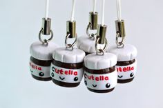 four little bottles with chocolate fillings on them hanging from strings in front of a white background