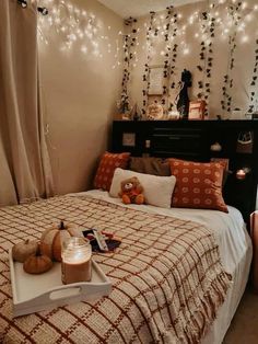 a bedroom with lights strung above the headboard and pillows on the bed, along with a teddy bear