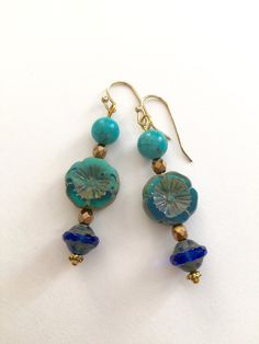 "Lightweight earrings handmade of semi-transparent aqua blue Czech glass Picasso flower, 8mm turquoise howlite, and cobalt blue Picasso UFO bead. Accented with light bronze Czech glass beads and gold wire. Earrings come on simple gold plated fish hook ear wires, lead and nickel free. Measure 2 1/8\"'long from top of ear wire." Blue Czech Glass Beach Jewelry, Artisan Blue Beaded Round Earrings, Artisan Blue Beaded Earrings, Nickel-free Blue Flower Earrings, Artisan Blue Earrings, Handmade Artisan Blue Earrings, Blue Flower Earrings Nickel Free, Blue Round Flower Earrings Hypoallergenic, Artisan Handmade Blue Earrings