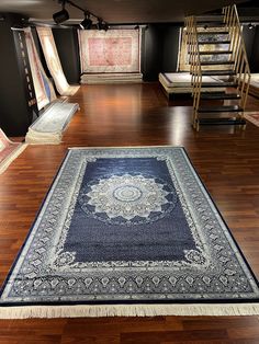 a large rug in the middle of a room with wooden floors and ladders on either side