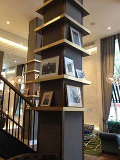 a tall wooden tower with pictures on it's sides in front of a living room