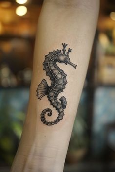 a small seahorse tattoo on the arm