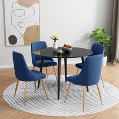 a dining room table with blue chairs and a bowl of fruit on the plate next to it