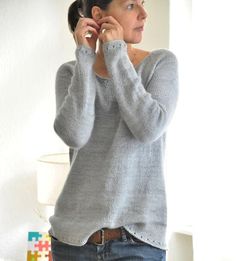 a woman standing in front of a mirror holding a cell phone to her ear and looking into the mirror