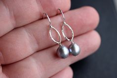 "Gorgeous gray, semi-baroque, freshwater pearl earrings. These beautiful gray pearls have amazing shine, are nearly blemish free, and have the most amazing deep lavender-gray hue. I have attached these pearls to a textured oval component; they hang from either sterling silver earwires or 14k gold filled earwires. Pearls measure 8.5mm. Overall length is 1\" Please select your preferred earring metal and style upon checkout. Your purchase will come securely packaged in a slate gray jewelry gift bo Gray Pearl Drop Jewelry For Gift, Silver Tahitian Pearl Earrings For Wedding, Elegant Gray Earrings With Ear Wire, Silver Tahitian Pearl Drop Earrings, Elegant Gray Sterling Silver Earrings, Elegant Nickel-free Gray Jewelry, Elegant Gray Earrings As Gift, Elegant Gray Earrings For Gift, Handmade Elegant Gray Jewelry