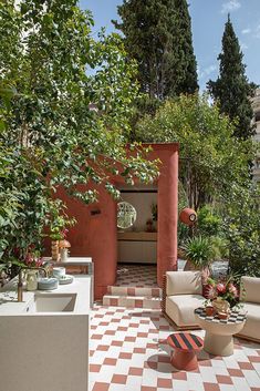 an outdoor living area with checkered tile flooring and orange walls, surrounded by trees