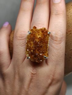 Make a Bold Statement with our Raw Citrine Ring! Elevate your style and showcase your unique personality with our exceptional Raw Citrine Ring. Crafted with a genuine, uncut citrine gemstone, this ring embodies the raw beauty of nature. The adjustable band ensures a perfect fit for any finger, providing both comfort and versatility. Made with sterling silver filled metal, this ring offers durability and a lustrous shine that complements the radiant citrine stone. Citrine is revered for its abili Citrine Gemstone Crystal Promise Ring, Citrine Crystal Promise Ring With Gemstone, Unique Citrine Gemstone Rings, Handmade Citrine Crystal Ring As Gift, Spiritual Amber Citrine Rings, Unique Citrine Gemstone Crystal Ring, Gold Rings With Natural Stones And Citrine, Handmade Gold Citrine Crystal Ring, Citrine Ring With Large Stone