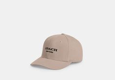 a baseball cap with the word coach printed on it in black and white, against a light gray background