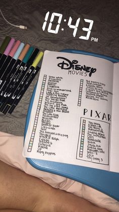 an open book with disney movies written on it next to crayons and markers