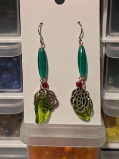 These earrings have stainless steel earring hooks. The long green plastic tube beads are vintage from the '90s, the green leaf charms are glass, and the flower charms are silver-tone. For reference, this mannequin's head is a bit smaller than an average adult head. Green Beaded Pierced Earrings, Green Metal Dangle Earrings, Green Metal Beaded Drop Earrings, Green Flower-shaped Pierced Earrings, Green Nickel Free Dangle Earrings, Nickel-free Green Dangle Earrings, Green Nickel-free Dangle Earrings, Nickel-free Green Metal Beaded Earrings, Nickel Free Green Metal Earrings