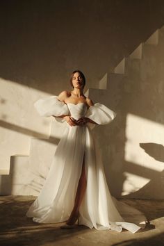 a woman in a white dress posing for the camera with her hands on her hips