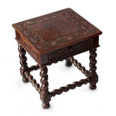 an old wooden table with intricate carvings on the top and bottom, sitting against a white background