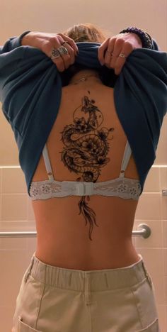 a woman with a dragon tattoo on her back