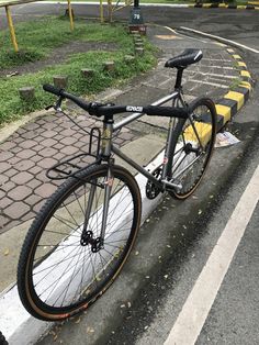 a bike parked on the side of a road next to a yellow line and some grass