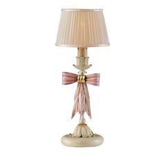 a table lamp with a pink bow on the top and a beige shade over it