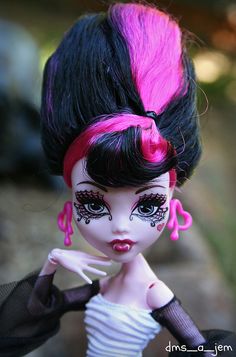 a doll with pink and black hair is posed