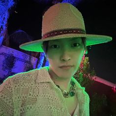 a woman wearing a white hat with green lights in the background