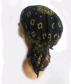 a mannequin head wearing a black bandana with yellow and green designs on it