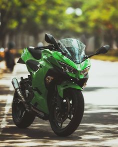 a green motorcycle is parked on the street