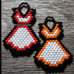 two pieces of beaded earrings sitting on top of a wooden table next to each other