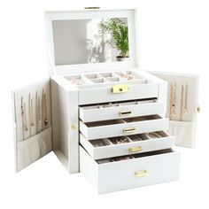 an open white jewelry box with five drawers and two plants in the top one drawer