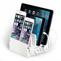 three cell phones are connected to an ipad and tablet in this charging station that holds multiple devices