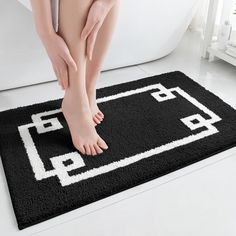 a woman's bare feet are sitting on a rug in front of a bathtub