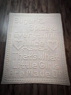 a white crocheted rug on a wooden floor with wood floors in the background