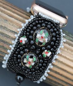 "This Apple watch band is lovingly hand embroidered with vintage beads and is backed securely with buttery Ultra Suede. Silver-toned connectors attach this bracelet to your 38-40,41mm Apple watch. Because of the variety in bead hues, this watch band coordinates well with all stainless steel, yellow gold, rose gold, silver, and space gray cases.  This 1 3/4\" wide watch band is fully adjustable from wrist size 6\" and up  simply by creating an overhand knot (see diagram with video at bottom  of page) in expandable elastic to perfectly fit your wrist. Because you  customize the fit, the watch will hug snugly and comfortably." Vintage Black Adjustable Watch Bands, Vintage Adjustable Bracelet Strap Apple Watch Band, Adjustable Vintage Bracelet Strap Apple Watch Band, Elegant Beaded Apple Watch Band As Gift, Vintage Black Beaded Bracelets, Vintage Handmade Adjustable Watch Bands, Adjustable Vintage Watch Bands As A Gift, Elegant Adjustable Beaded Watch Bands, Adjustable Black Beaded Apple Watch Band