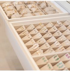 an open drawer with several pairs of jewelry in it and the lid opened to show many different types of earrings