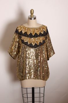 1980s Gold, Black and Blue Half Sleeve Zig Zag Pullover Silk and Sequin Blouse  This blouse features: *Gold, black and blue colors *Half sleeve *Pullover *Zig zag pattern around collar *Silk and sequin material  Label: Made in India Size: Fits up to X-Large  Measurements: Bust: 48" Waist: 45" Length: 25" Condition: Excellent If you have any questions, please ask! Find even more Vintage X Large-XX Large at: https://www.etsy.com/shop/NaughtyKittyVintage?section_id=17610199&ref=shopsection_leftnav_ Vintage Gold Crew Neck Top, Vintage Gold Blouse For Party, Vintage Blouse For Festive Occasions, Vintage Tops For Night Out In Fall, Vintage Party Tops, Vintage Gold Tops For Night Out, Sequin Blouse, Zig Zag Pattern, Half Sleeve