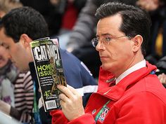 a man in red jacket holding up a magazine