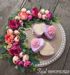 two heart shaped shoes with flowers and pearls on the bottom are sitting on a table